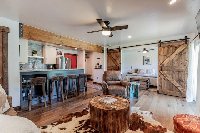 2235 Storm Meadows Dr Unit 312, Steamboat Springs, CO 80477 - living room featuring a barn door, wood-type flooring, a ceiling fan, and recessed lighting