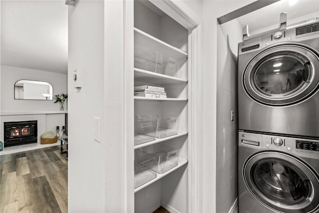 1300 Athens Plz Unit 2, Steamboat Springs, CO 80487 - laundry room with stacked washing machine and dryer, wood finished floors, and a glass covered fireplace