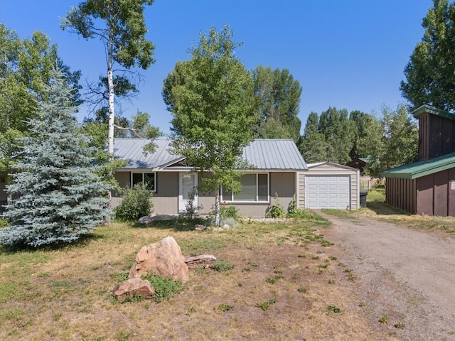 2646 Riverside Dr Unit A, Steamboat Springs, CO 80487 - view of front of home featuring an attached garage, driveway, a metal roof, and an outbuilding