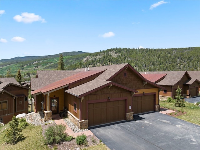799 Independence Rd Unit 799, Keystone, CO 80435 - rustic home featuring stone siding, roof with shingles, an attached garage, asphalt driveway, and a mountain view