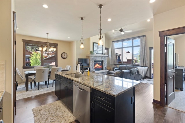 799 Independence Rd Unit 799, Keystone, CO 80435 - kitchen featuring stainless steel dishwasher, dark cabinetry, a stone fireplace, open floor plan, and a ceiling fan
