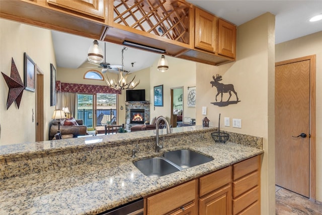 1660 Lakeview Ter Unit 306F, Frisco, CO 80443 - kitchen with open floor plan, a sink, a fireplace, a chandelier, and light stone counters