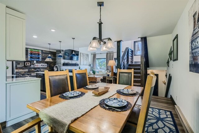 111 Corinthian Cir Unit D, Dillon, CO 80435 - dining room with stairway, a notable chandelier, wood finished floors, and baseboard heating