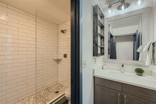 bathroom with toilet, vanity, and a stall shower