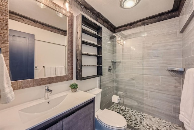 full bathroom featuring toilet, vanity, and a tile shower