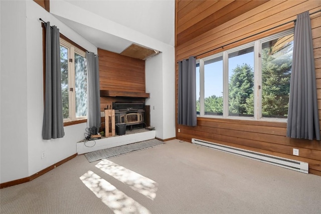 2495/2497 Val Disere Cir, Steamboat Springs, CO 80487 - unfurnished living room with a baseboard radiator, a wood stove, wood walls, and carpet