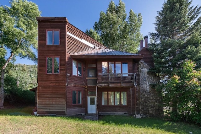 2495/2497 Val Disere Cir, Steamboat Springs, CO 80487 - back of house featuring a metal roof, a lawn, a balcony, and a standing seam roof