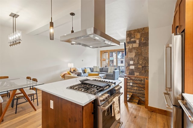 317 Granite St Unit 3, Frisco, CO 80443 - kitchen featuring stainless steel appliances, wall chimney range hood, light wood finished floors, brown cabinetry, and open floor plan
