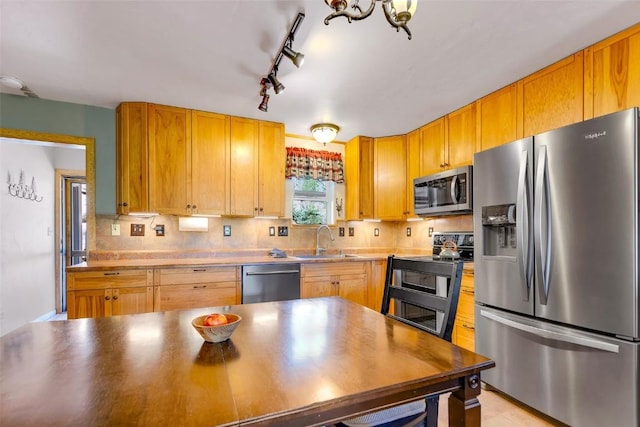 216 Ambush Ln, Jefferson, CO 80456 - kitchen with appliances with stainless steel finishes, rail lighting, decorative backsplash, and a chandelier