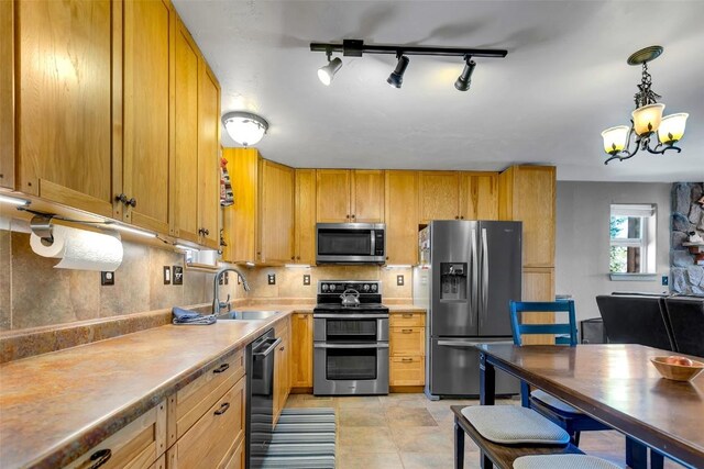 216 Ambush Ln, Jefferson, CO 80456 - kitchen featuring appliances with stainless steel finishes, a chandelier, backsplash, light countertops, and hanging light fixtures