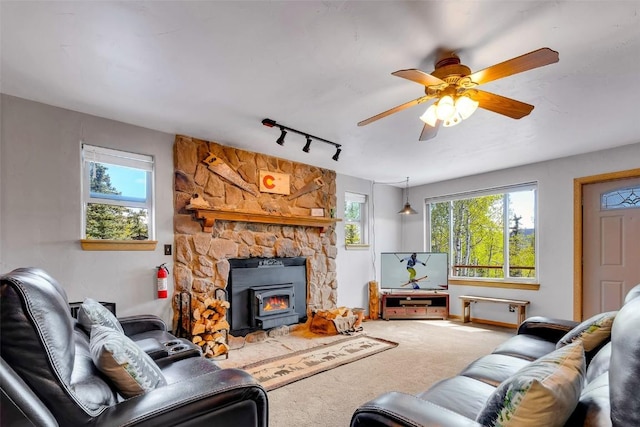 216 Ambush Ln, Jefferson, CO 80456 - carpeted living area with a wood stove, healthy amount of natural light, a ceiling fan, and rail lighting