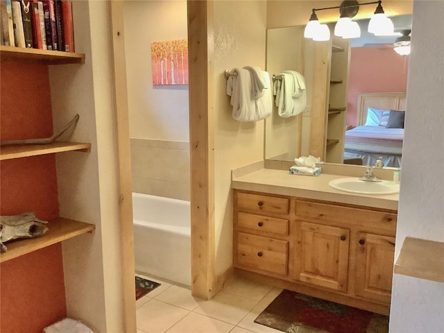 bathroom with a bath, vanity, and tile patterned floors