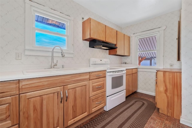 401 Moffat Ave, Oak Creek, CO 80467 - kitchen with white range with electric cooktop, under cabinet range hood, wallpapered walls, a sink, and brick patterned flooring