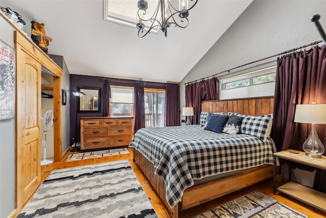 876 Broken Lance Dr Unit 876, Breckenridge, CO 80424 - bedroom with lofted ceiling, wood finished floors, multiple windows, and a chandelier