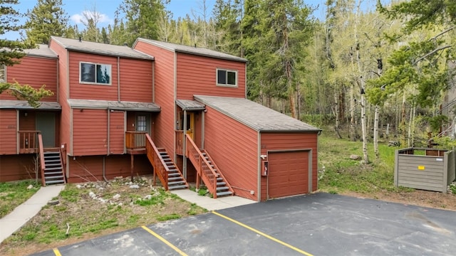876 Broken Lance Dr Unit 876, Breckenridge, CO 80424 - view of front facade with stairway, a garage, and asphalt driveway