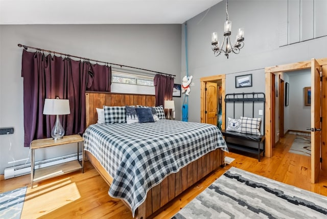 876 Broken Lance Dr Unit 876, Breckenridge, CO 80424 - bedroom featuring baseboard heating, a chandelier, high vaulted ceiling, and light wood finished floors