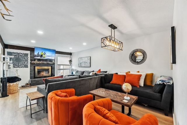 living room featuring a premium fireplace, wood finished floors, and recessed lighting