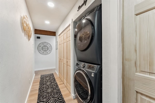 laundry area featuring light wood finished floors, baseboards, stacked washer / dryer, recessed lighting, and laundry area