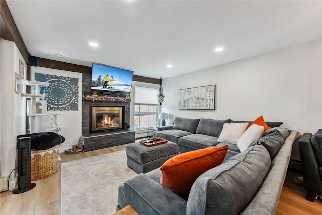 living area with a glass covered fireplace, wood finished floors, and recessed lighting
