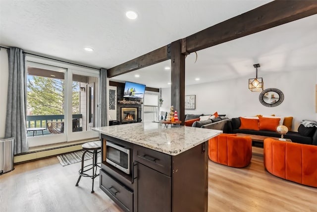 kitchen with a baseboard radiator, light wood-style floors, open floor plan, and recessed lighting
