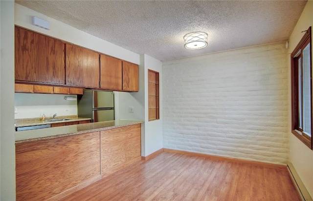 8 Sequoia Ct Unit 8, Steamboat Springs, CO 80487 - kitchen with freestanding refrigerator, a baseboard heating unit, baseboards, light wood-style flooring, and brown cabinetry