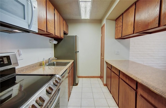 8 Sequoia Ct Unit 8, Steamboat Springs, CO 80487 - kitchen featuring stainless steel appliances, a sink, light countertops, brown cabinets, and a textured ceiling
