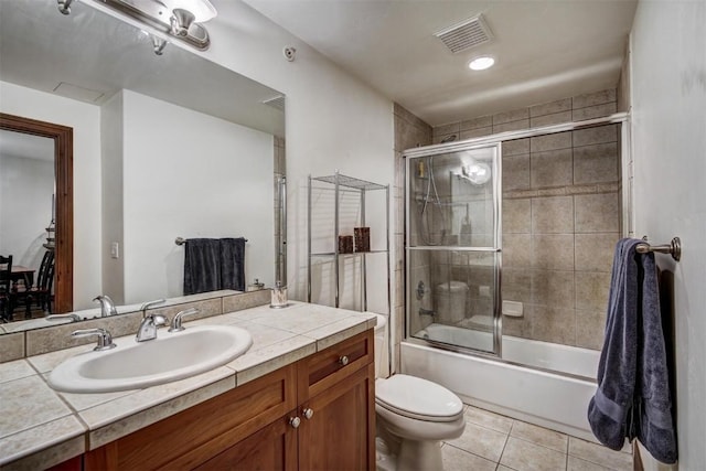 full bathroom with tile patterned flooring, enclosed tub / shower combo, vanity, and toilet