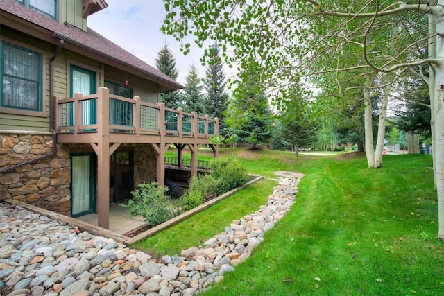 view of green lawn with a deck