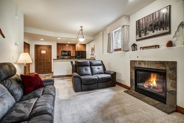 living area with light colored carpet, a stone fireplace, recessed lighting, and baseboards