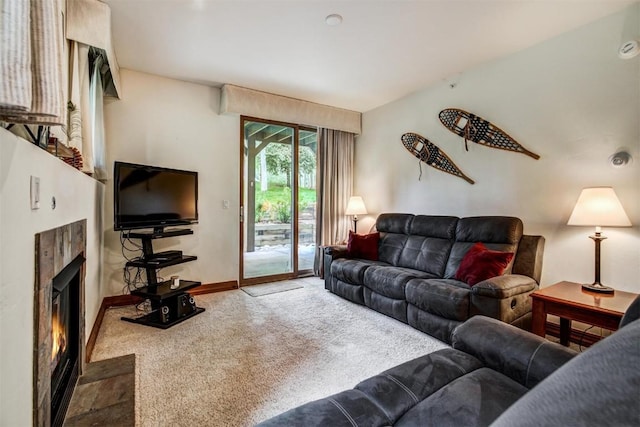 carpeted living area featuring a fireplace with flush hearth and baseboards