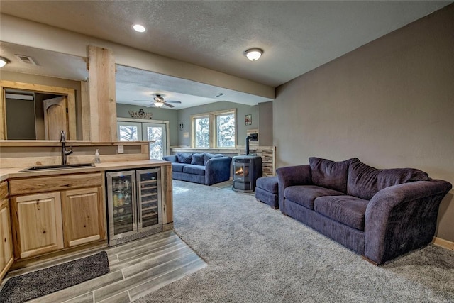 3222 Middle Fork Vis, Fairplay, CO 80440 - living area featuring wine cooler, light wood-style flooring, bar area, a textured ceiling, and baseboards
