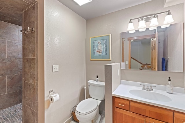 284 Lakeshore Loop, Blue River, CO 80424 - full bathroom with a tile shower, toilet, vanity, baseboards, and a textured wall