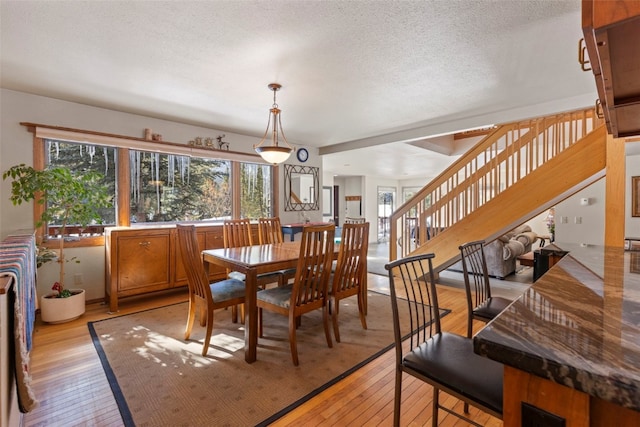 284 Lakeshore Loop, Blue River, CO 80424 - dining space with stairway, light wood-style floors, and a textured ceiling