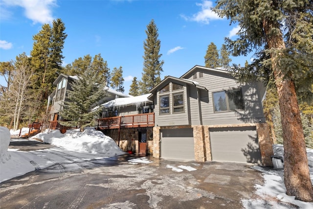 284 Lakeshore Loop, Blue River, CO 80424 - view of snow covered exterior with a garage, driveway, and stone siding