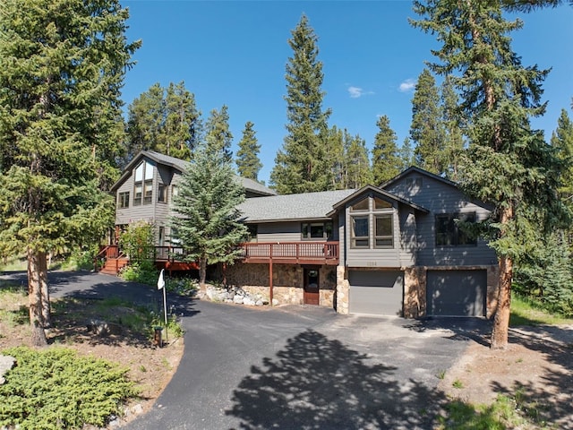 284 Lakeshore Loop, Blue River, CO 80424 - rustic home with driveway, an attached garage, stone siding, and a deck