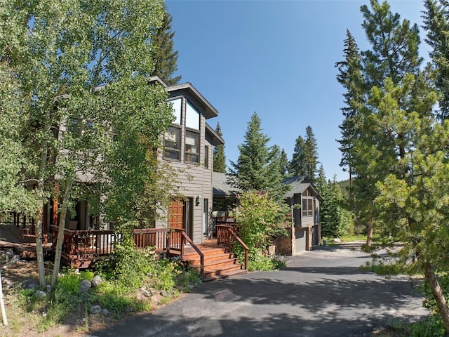284 Lakeshore Loop, Blue River, CO 80424 - view of front facade with a garage, a wooden deck, and asphalt driveway