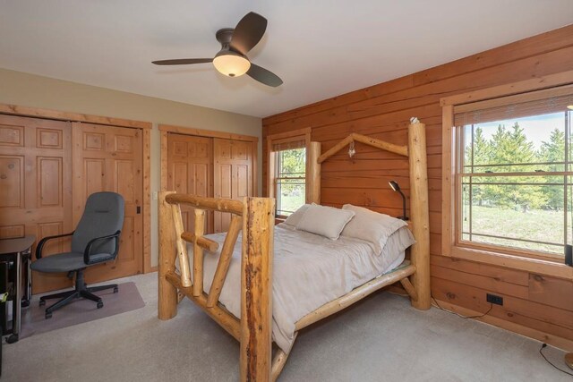 12000 Ute Pass Rd, Parshall, CO 80468 - bedroom featuring carpet, wood walls, multiple closets, and a ceiling fan