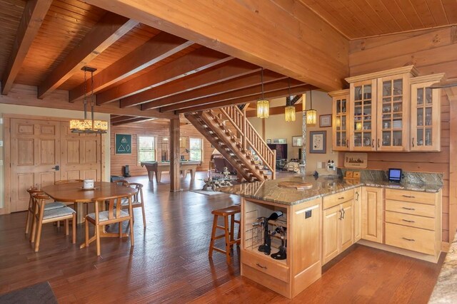 12000 Ute Pass Rd, Parshall, CO 80468 - kitchen featuring wooden walls, wood ceiling with exposed beams, dark wood-style flooring, light stone countertops, and a peninsula