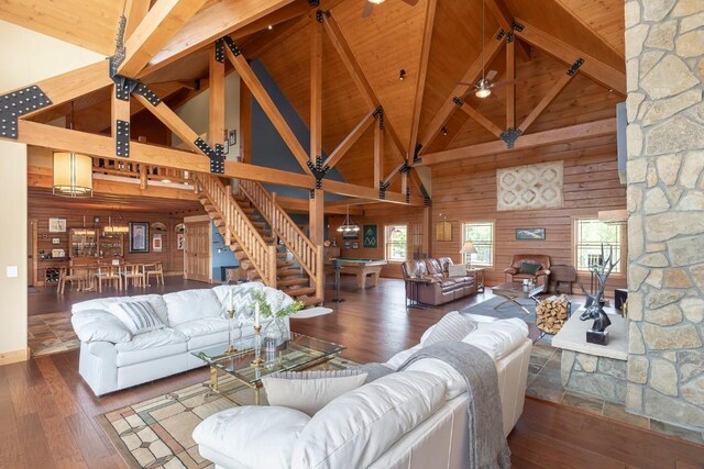 12000 Ute Pass Rd, Parshall, CO 80468 - living room featuring high vaulted ceiling, wooden ceiling with exposed beams, hardwood / wood-style floors, wood walls, and stairway