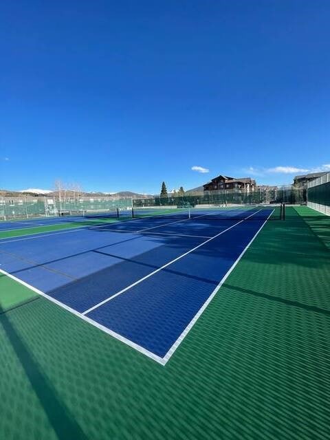 view of tennis court featuring fence