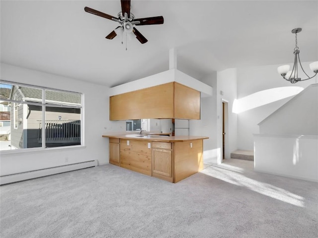 kitchen featuring vaulted ceiling, decorative light fixtures, sink, light colored carpet, and kitchen peninsula