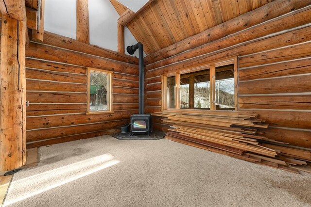57785 Saturn Ct, Clark, CO 80428 - unfurnished room with a wood stove, carpet flooring, log walls, wood ceiling, and high vaulted ceiling