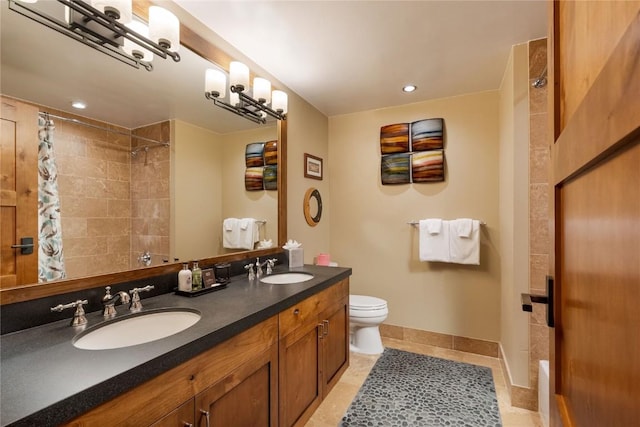 bathroom with toilet, baseboards, a tile shower, and a sink