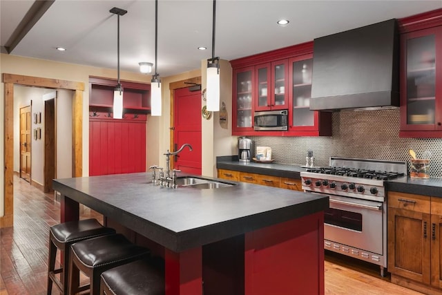 2250 Apres Ski Way Unit R105, Steamboat Springs, CO 80487 - kitchen featuring dark countertops, wall chimney range hood, tasteful backsplash, a sink, and appliances with stainless steel finishes