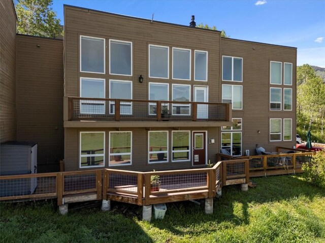 30311 County Road 16 Unit 105, Oak Creek, CO 80467 - rear view of house featuring a balcony and a lawn