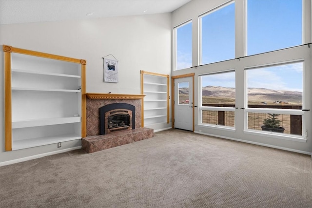 30311 County Road 16 Unit 105, Oak Creek, CO 80467 - unfurnished living room featuring carpet floors, plenty of natural light, a high ceiling, and a premium fireplace