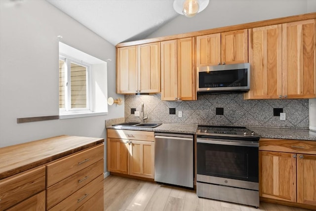 30311 County Road 16 Unit 105, Oak Creek, CO 80467 - kitchen with stainless steel appliances, vaulted ceiling, a sink, and tasteful backsplash