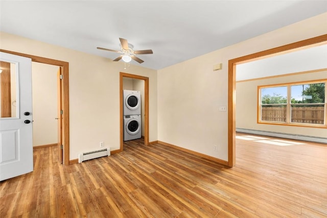 407 S 3rd St Unit 407, Hayden, CO 81639 - unfurnished room with stacked washing machine and dryer, a baseboard heating unit, wood finished floors, and a ceiling fan