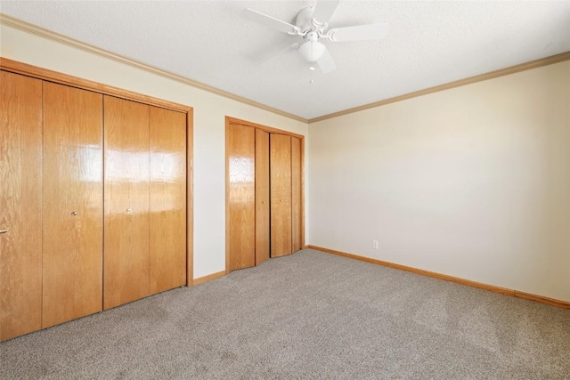 407 S 3rd St Unit 407, Hayden, CO 81639 - unfurnished bedroom with two closets, carpet flooring, ornamental molding, and a ceiling fan