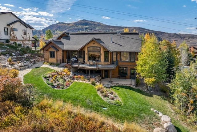 1138 Longview Cir, Steamboat Springs, CO 80487 - back of house with a mountain view, a patio, a lawn, and roof with shingles
